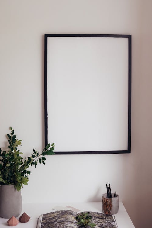 Paper template layout on a wall with painter's tape holding cutouts in position before hanging