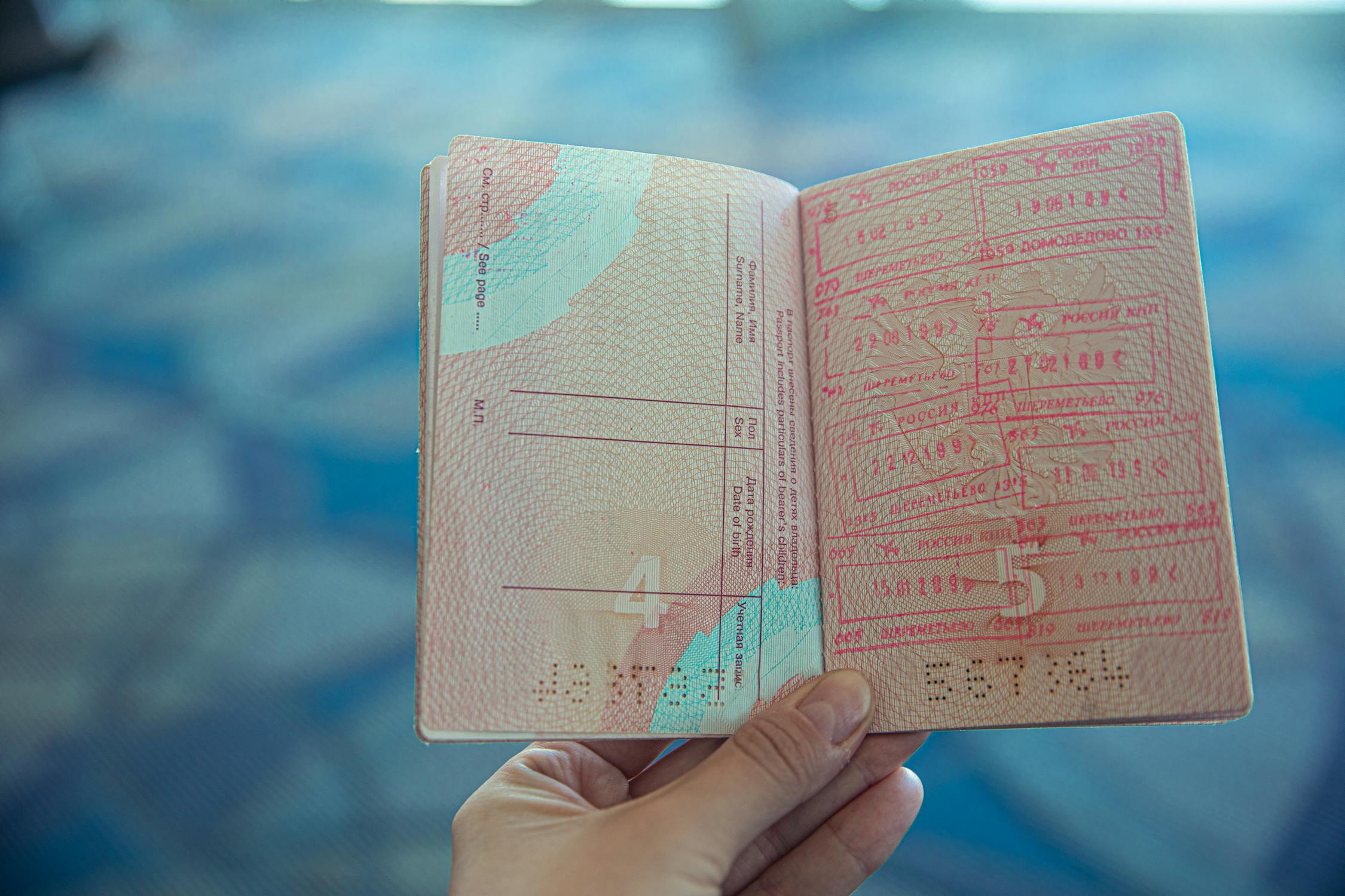 An open passport with visa stamps — the document that controls the lives of hundreds of thousands of H-1B workers in Austin and across America
