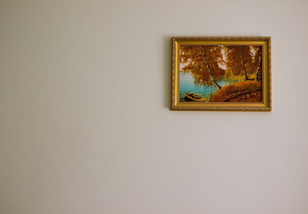 A living room with artwork illuminated by warm, angled picture lights creating a gallery-like atmosphere